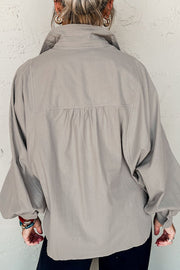 Light gray balloon sleeve button-down blouse with gathered back detail.