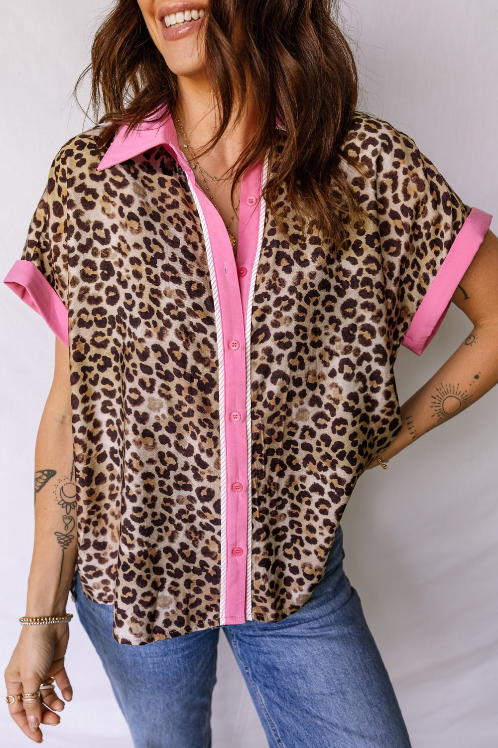 Leopard print short sleeve button up shirt with pink collar and cuffs.