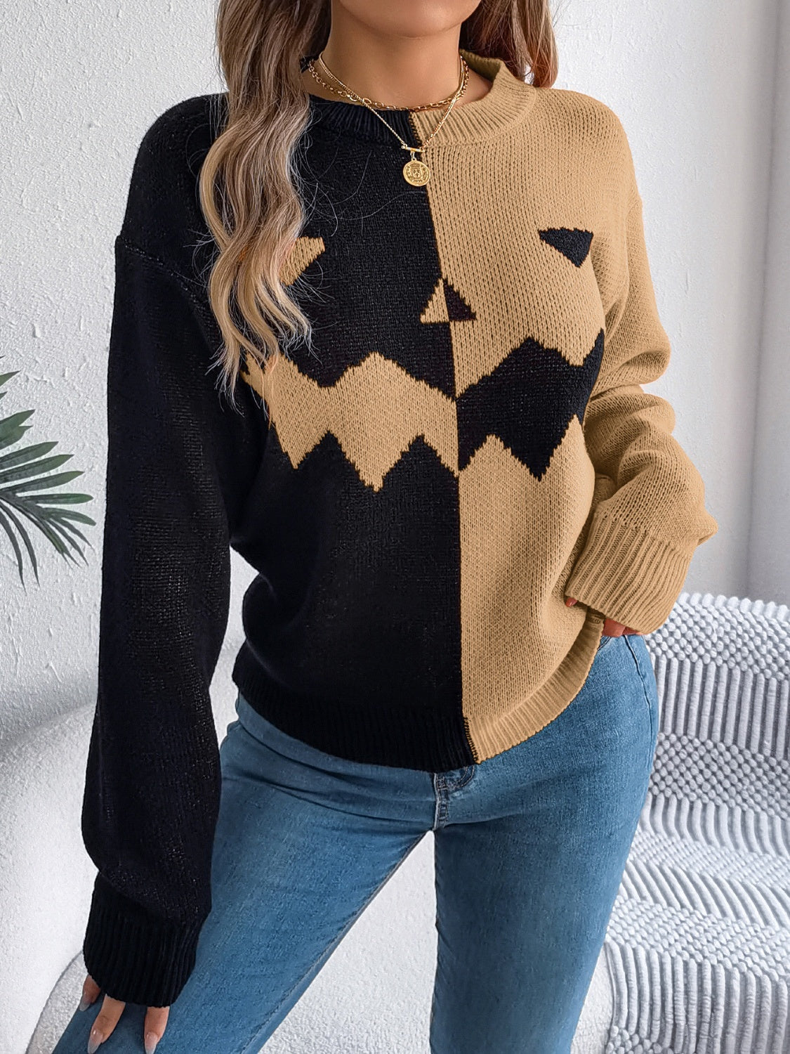 Split-face pumpkin knit sweater in black and camel with crew neck and long sleeves.