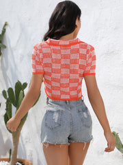 Orange-red and white checkerboard knit cropped polo shirt with short sleeves and collar.