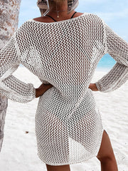 White open-knit beach dress with long sleeves and side slit, styled with a bikini.