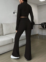 Black ribbed knit flare co-ord set with a cropped long sleeve top and high waisted flared pants.