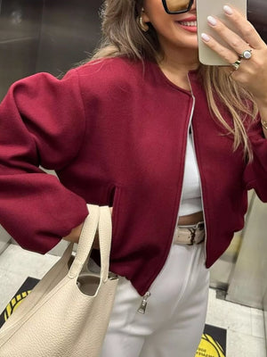 Burgundy zip up cropped bomber jacket with a round neckline and pockets.