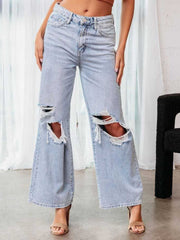 Distressed light wash denim wide leg flare jeans with ripped knees.
