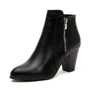 Black laser-cut detail block heel booties with side zipper and pointed toe.