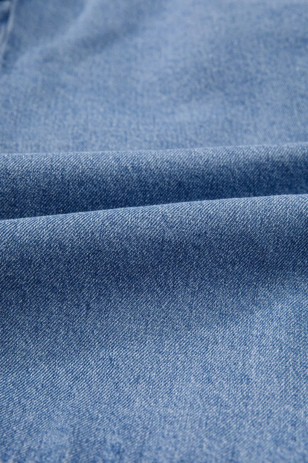 Denim bow-tie peplum blouse in medium wash denim fabric with a textured weave.