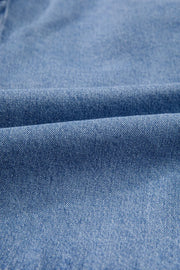 Denim bow-tie peplum blouse in medium wash denim fabric with a textured weave.