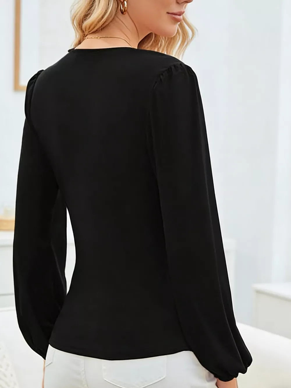Black polyester maternity blouse with ruched long sleeves and a V-neckline.