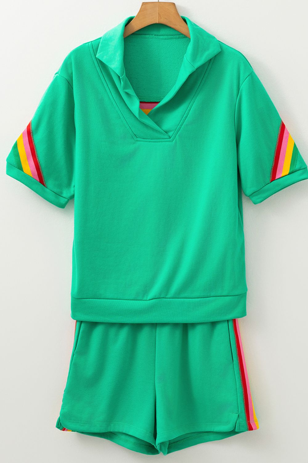 Green activewear shorts and top set with rainbow stripe details on sleeves and shorts.