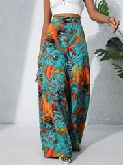 Tropical leaf print palazzo trousers in teal, orange-red, and black.