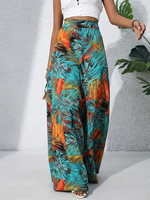 Tropical leaf print palazzo trousers in teal, orange-red, and black.