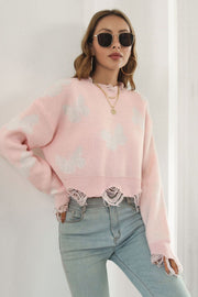 Blush pink acrylic knit sweater with white butterfly intarsia, frayed hem and cuffs, cropped length.