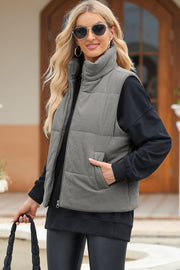 Corduroy funnel neck puffer vest in Dark Gray with zip front and pockets.