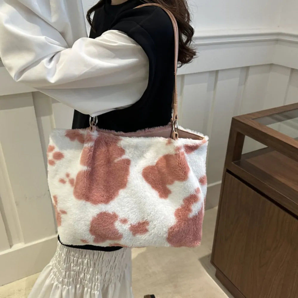 Dusty pink cowhide print faux fur shopper bag with pink trim and leather straps.