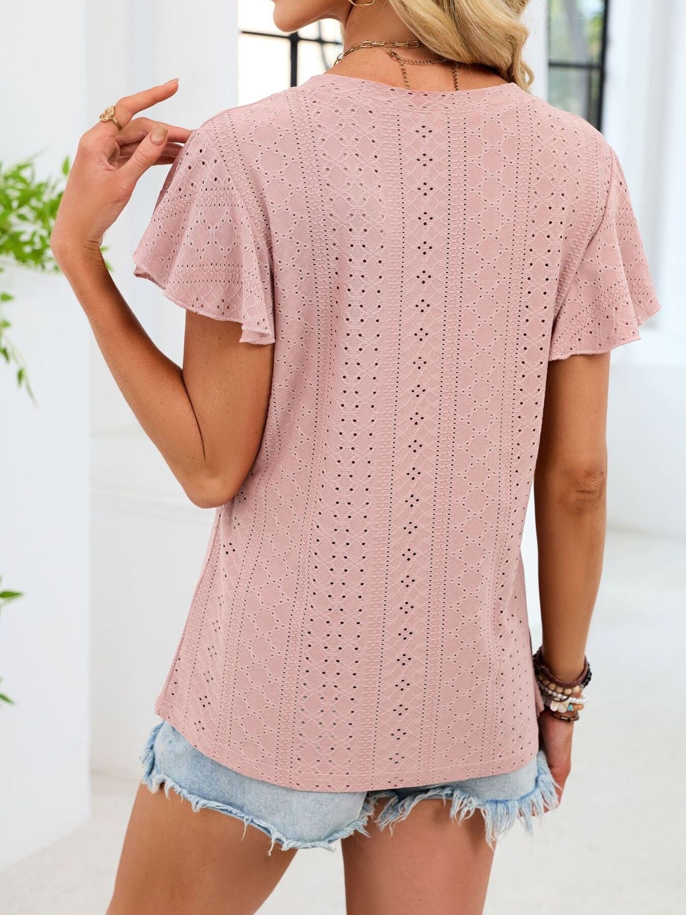 Skin powder eyelet flutter sleeve t-shirt with a relaxed fit.