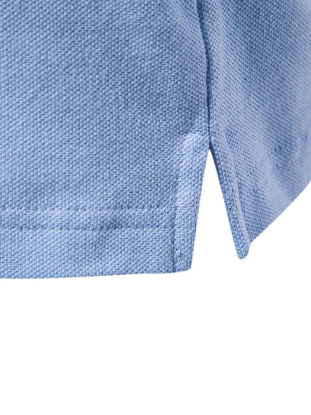 Light blue textured polo shirt detail showing side vent and stitching