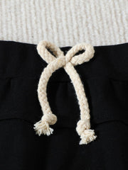 Black cotton baby set shorts with cream drawstring and frayed ends.