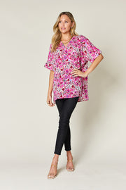 Pink floral ikat relaxed v-neck blouse with short sleeves.