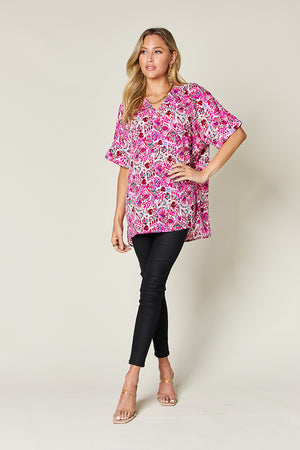 Pink floral ikat relaxed v-neck blouse with short sleeves.