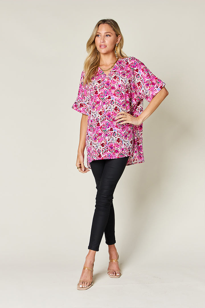 Pink floral ikat relaxed v-neck blouse with short sleeves.