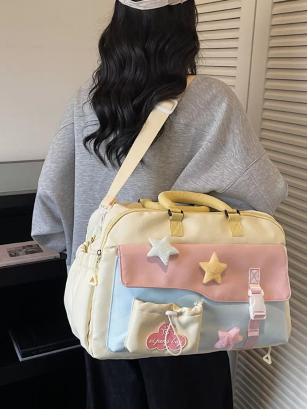 Chic color block travel bag with star embellishments and multiple pockets.