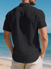 Black short sleeve henley shirt with band collar and textured cotton fabric.