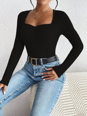 Black ribbed bodysuit with sweetheart neckline and ruched detail, long sleeves.