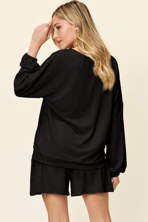 Black waffle knit lounge set with blouson sleeves and matching shorts.