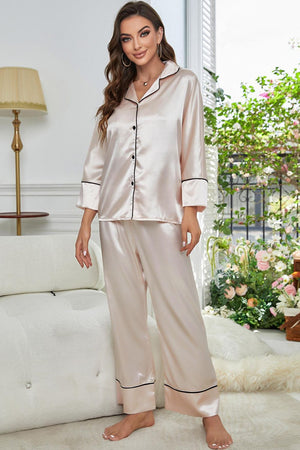 Beige satin pajama set with black satin trim, long sleeves, and button-up top.