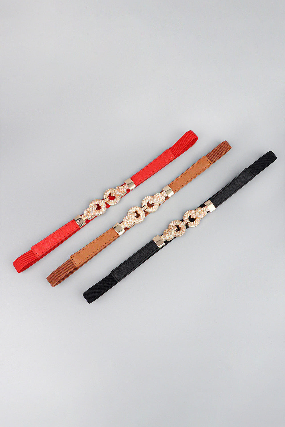 Linked knot elasticated waist belts in red, caramel, and black with alloy detail