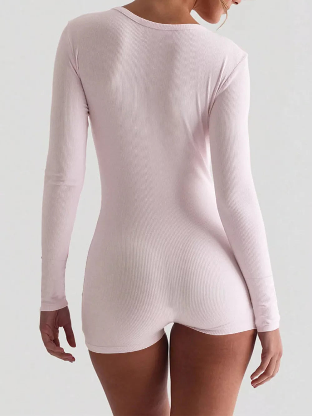 Pink ribbed knit long sleeve romper with button detail, showing the back view.