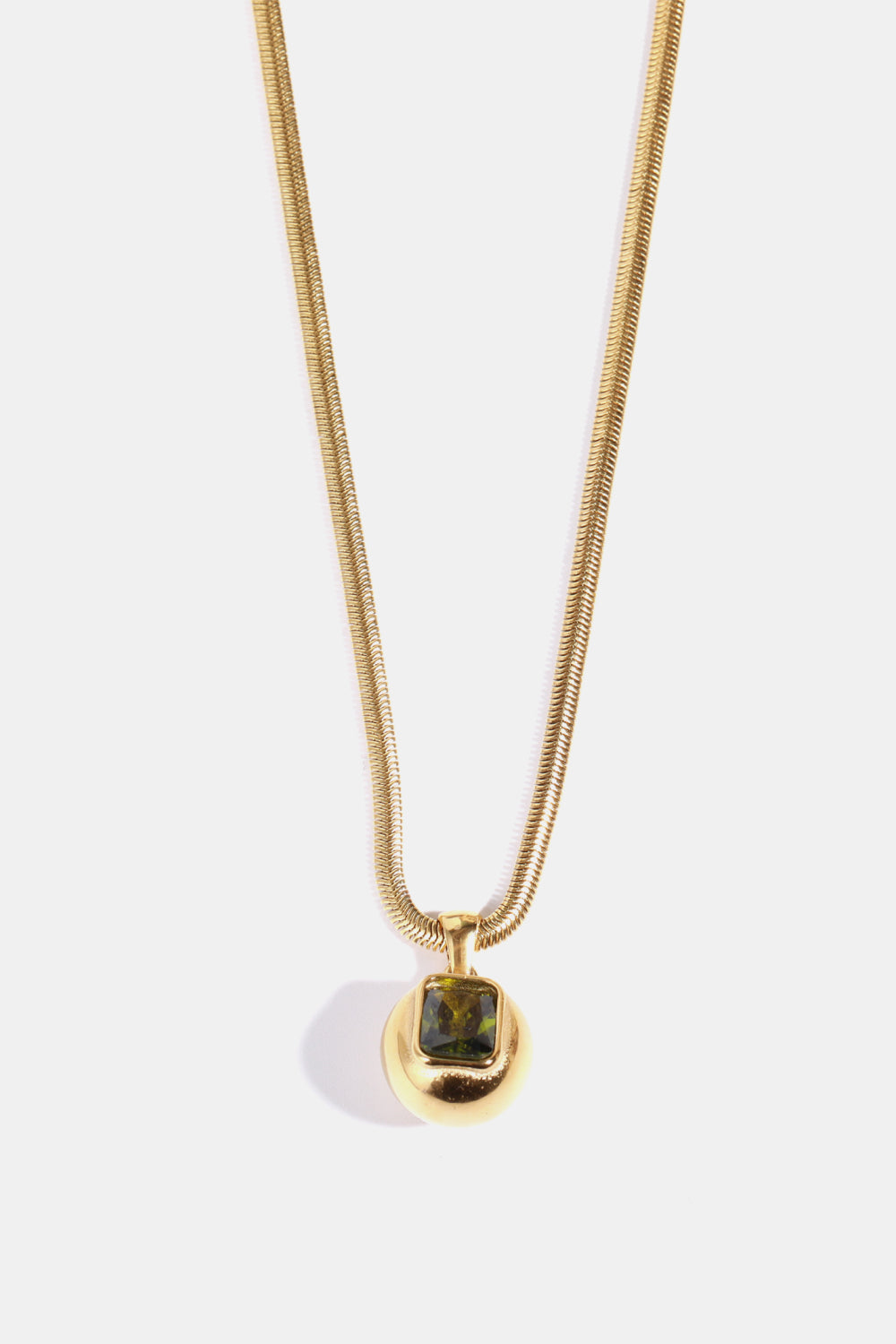 Gold necklace with orb pendant and green square stone