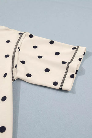 White polka dot bikini top with black stitching detail.