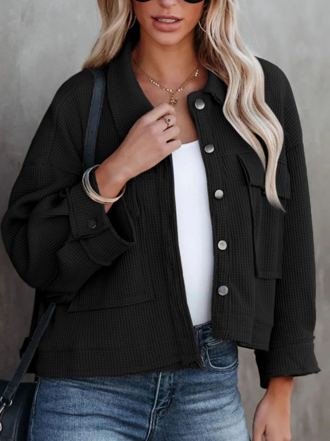 Black waffle knit cropped utility jacket with button front and chest pockets.