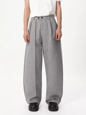 Gray relaxed wide-leg pleated trousers with a high waist and button closure.