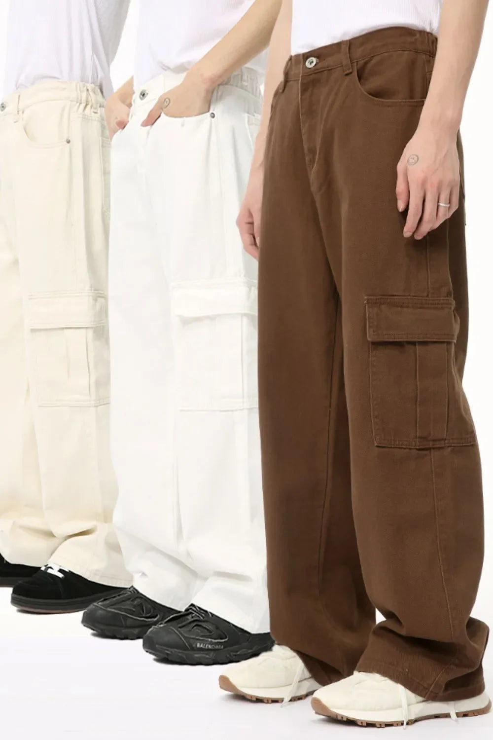 Brown cargo pants with flap pockets, shown on models with ivory and white pants.