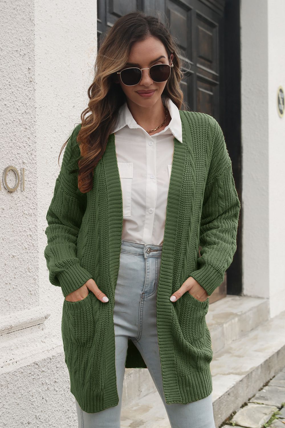 Army green cable knit longline cardigan with pockets and ribbed cuffs.