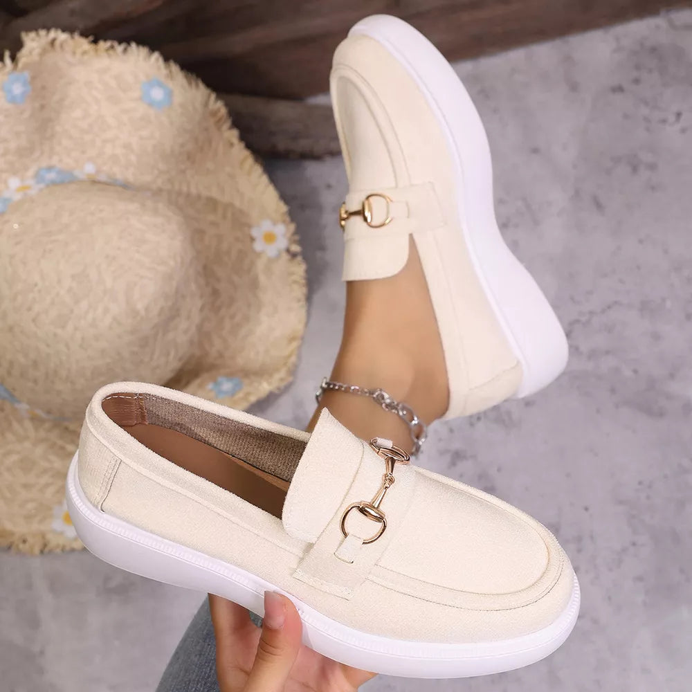 White loafers with gold horse-bit detail and side cutouts.