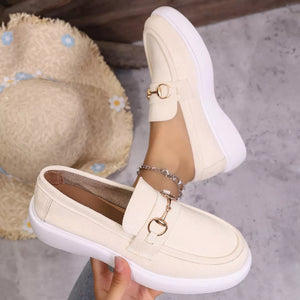 White loafers with gold horse-bit detail and side cutouts.
