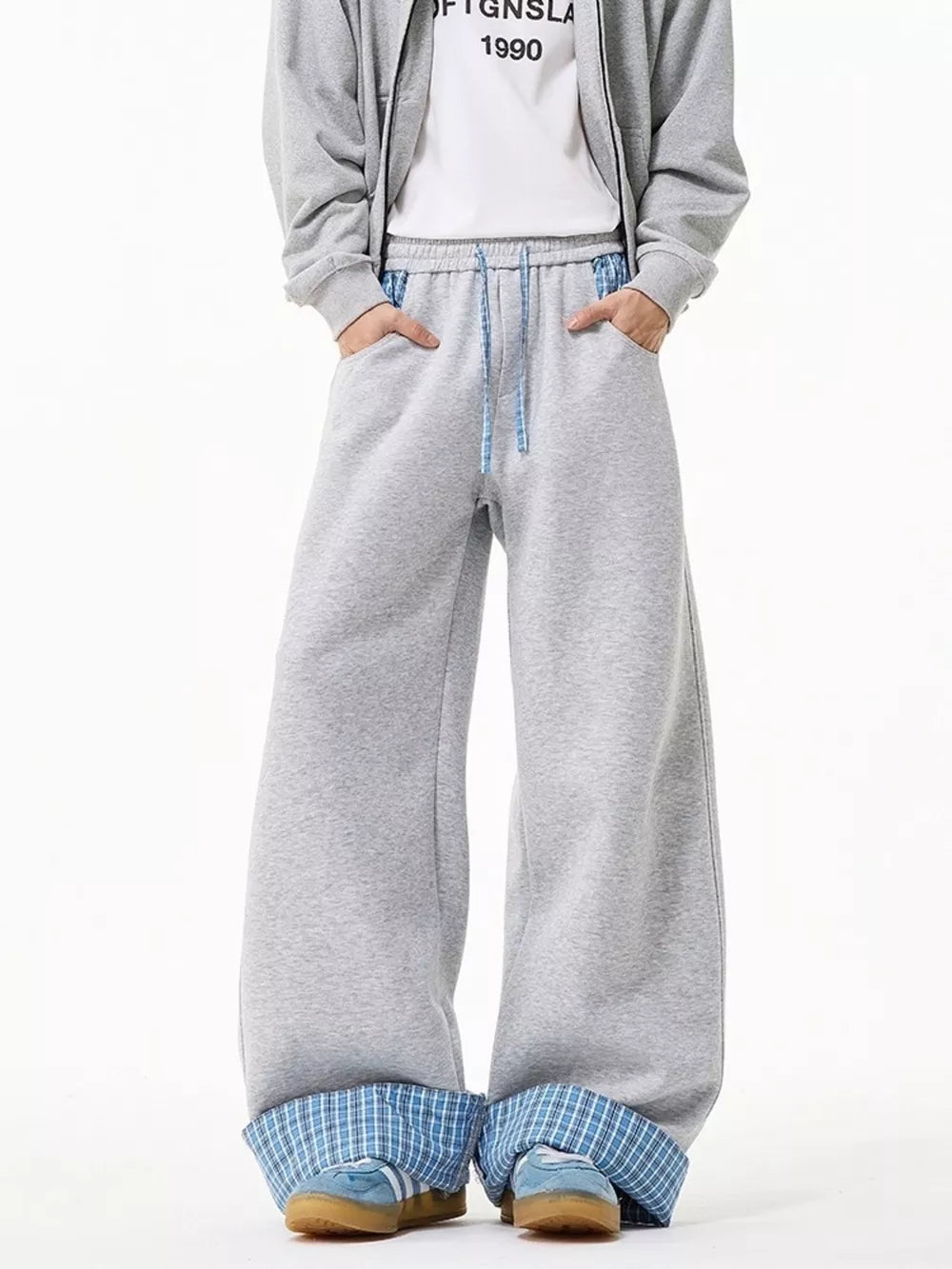 Gray wide-leg sweatpants with drawstring and blue plaid cuffs.