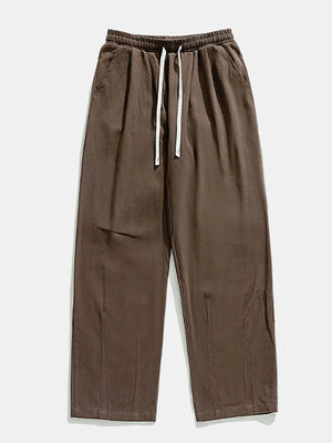 Wide-leg pleated trousers in coffee brown with drawstring waist and pockets.