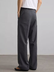Grey pleated wide-leg trousers with a relaxed fit, shown from the back.