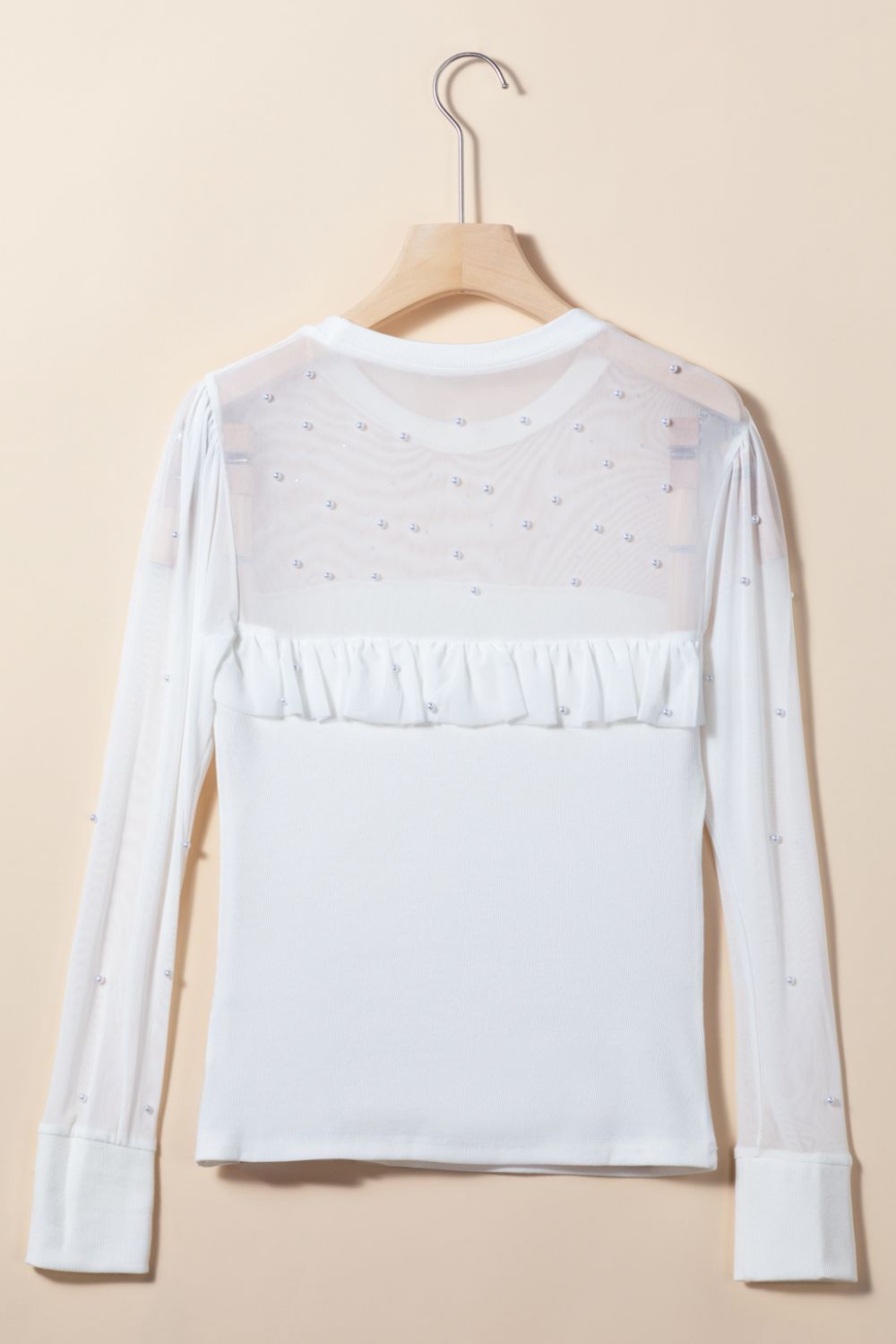 White long sleeve bodysuit with pearl-embellished mesh yoke and ruffled detail.