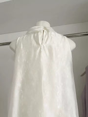 Sleeveless white shirt with subtle floral pattern and back zipper detail.