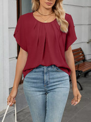 Sophisticated pleated short sleeve blouse in wine red polyester, with a round neckline.