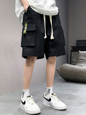 Men's black lightweight cargo shorts with drawstring and green tab detail.