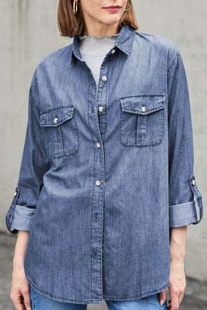 Relaxed light blue denim shirt with buttoned patch pockets and rolled sleeves.