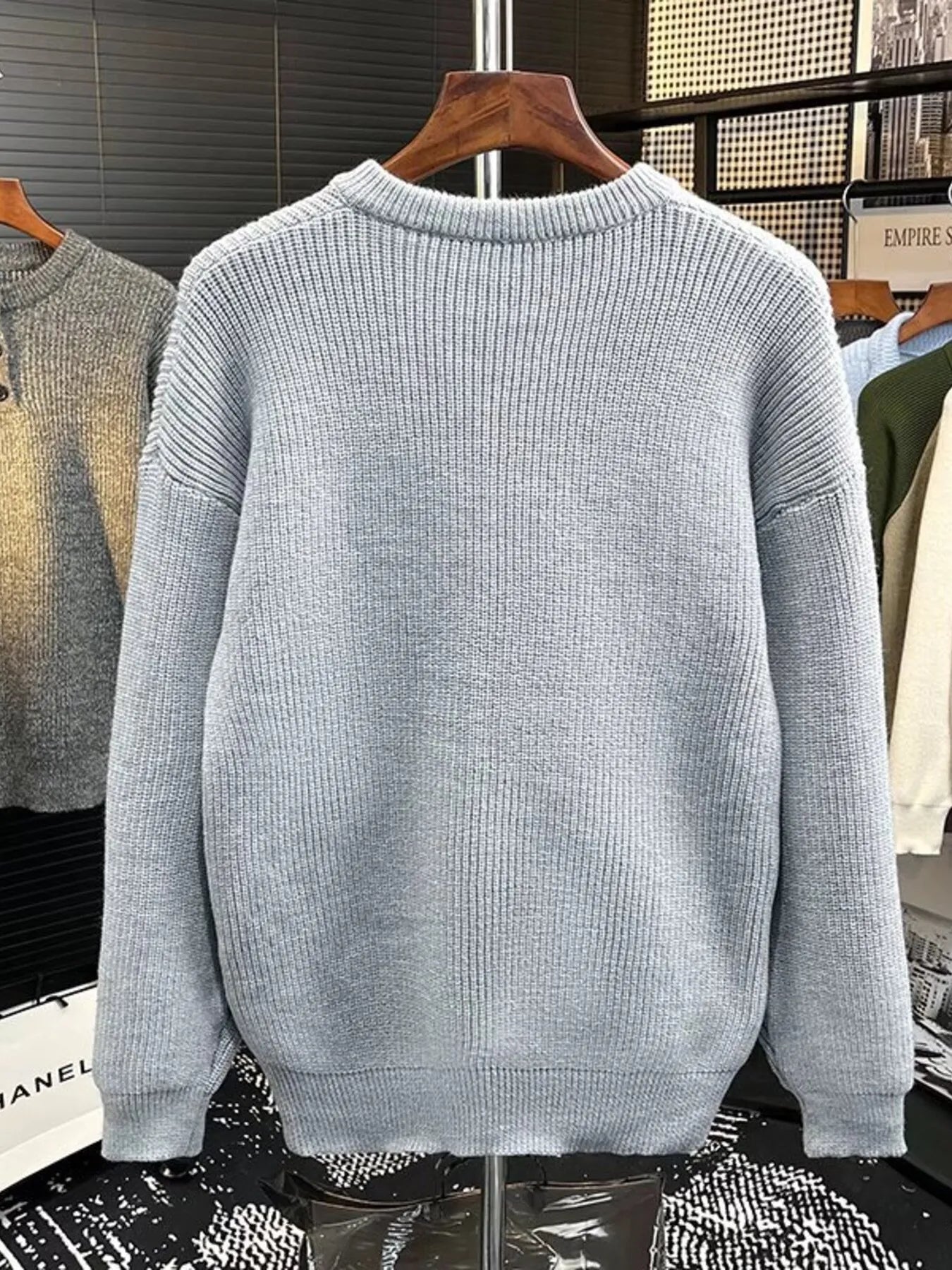 Light gray ribbed knit sweater with button detail on the neckline.