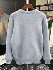 Light gray ribbed knit sweater with button detail on the neckline.