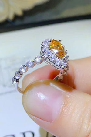 Gold halo ring with pear-cut amber gemstone and diamond accents